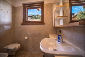bagno con lavandino, servizi igienici e finestra di Chalet Teola a Livigno
