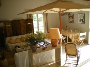 a living room with a table and an umbrella at Charming country house with panoramic views in Séguret