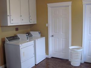 lavadero con lavadora y puerta blanca en HI-Bonavista Hostel, en Bonavista