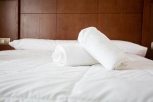 una pila de toallas enrolladas en una cama en Hotel Villa De Cárcar, en Cárcar