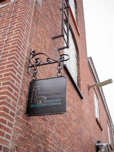una señal en el lateral de un edificio de ladrillo en De Oude Kazerne Torenkamer, en Kaatsheuvel