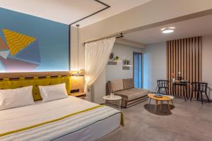 a hotel room with a bed and a living room at Mythic Summer Hotel in Paralia Katerinis