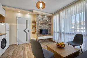 een woonkamer met een televisie en een tafel en stoelen bij ROMANCE APARTAMENT & Free Parking in Boergas