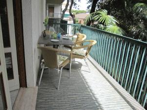 eine Terrasse mit einem Tisch und Stühlen auf dem Balkon in der Unterkunft Appartamento Pineta in Grado