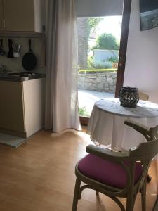 uma cozinha com uma mesa, uma cadeira e uma janela em Apartments Veli Lošinj em Veli Lošinj