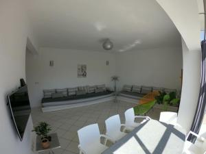 - un salon avec des fauteuils blancs et un canapé dans l'établissement Tanger Cap Spartel - Duplex 110m2 face aux plages, à Tanger