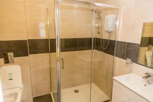 a bathroom with a shower and a toilet and a sink at Halfway Hotel in Coalville