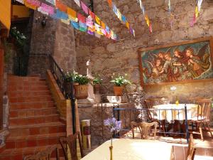 a restaurant with a staircase and tables and colorful flags at El Meson de los Poetas in Guanajuato