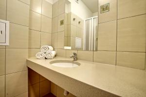 a bathroom with a sink and a mirror and towels at Biały Łabędź - Własne pomosty i kajaki in Kretowiny