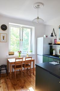 a kitchen with a wooden table and a kitchen with a refrigerator at Kafka in Sandomierz