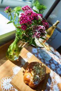 un jarrón de flores sentado en una mesa con un jarrón de flores en Kafka, en Sandomierz