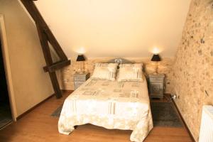 ein Schlafzimmer mit einem Bett und zwei Nachttischen in der Unterkunft Les Granges Indigo in Fossemagne