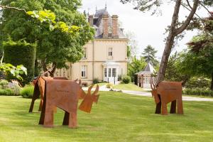 twoulptures of elephants in the grass in front of a house at Les Villas d'Arromanches, Teritoria in Arromanches-les-Bains