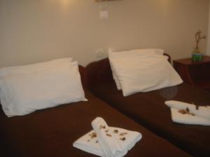 1 cama con 2 almohadas blancas y toallas en Iliaktida Apartments en Kolymvari