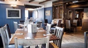 a dining room with wooden tables and chairs at De Trafford Arms by Chef & Brewer Collection in Alderley Edge