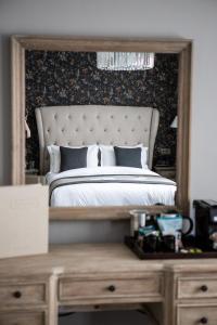 una camera da letto con un letto con un grande specchio sopra una scrivania di The Hayden Pub & Rooms a Londra