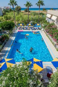 a large swimming pool with people in it with umbrellas at Missiria Apartments in Rethymno