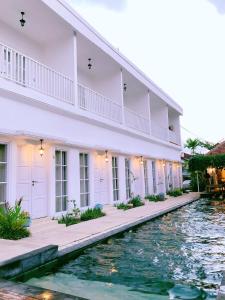a white building with water in front of it at Hikari Guesthouse in Seminyak