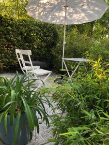 a chair and an umbrella in a garden with a plant at Guesthouse Poppies in Ostend