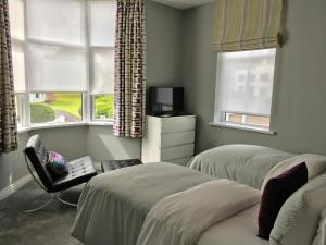 a bedroom with two beds and two windows at Hillrise B&B in Portrush