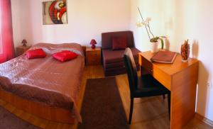 a bedroom with a bed and a desk and a chair at Guesthouse Liska in Mostar