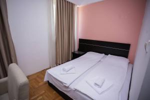 una camera da letto con un letto con due asciugamani bianchi di Hotel Beograd - Yu a Sarajevo