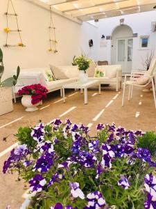 a living room with purple flowers and couches at Nonna Mina in Felline