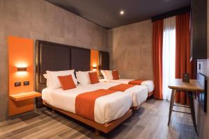 pokój hotelowy z dwoma łóżkami i telewizorem w obiekcie J24 Hotel Milano w Mediolanie