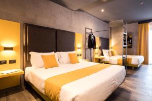 Pokój hotelowy z dużym łóżkiem z żółtymi poduszkami w obiekcie J24 Hotel Milano w Mediolanie