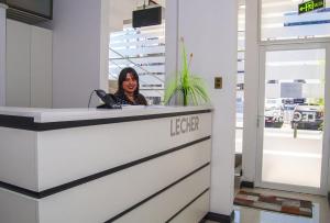 una mujer sentada en una recepción en una oficina en Hostal Lecher, en Iquique