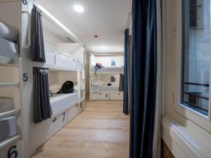 马德里room00 Gran Vía Hostel的走廊通往带双层床的客房