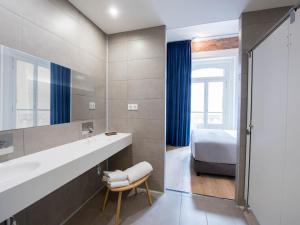 a bathroom with a bed and a sink and a mirror at room00 Gran Vía Hostel in Madrid