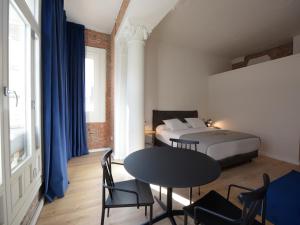 a bedroom with a bed and a table and chairs at Bluesock Hostels Madrid in Madrid