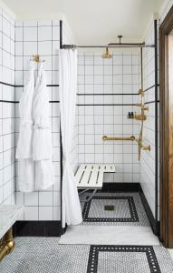 a bathroom with a shower with white tiles at The Ludlow Hotel in New York