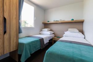 2 camas en una habitación pequeña con ventana en Vila Gallo en Galovac
