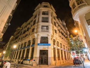 マドリードにあるroom00 Gran Vía Hostelの夜の街路にある大きな白い建物
