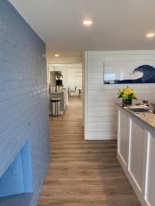 a kitchen with a blue brick wall and wooden floors at Breakwater Hotel in Provincetown