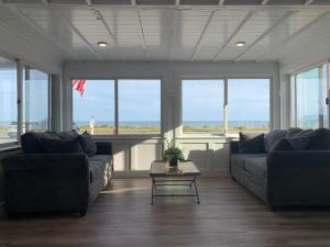 a living room filled with furniture and a large window at Breakwater Hotel in Provincetown