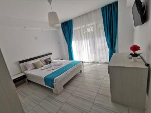 a bedroom with a bed with blue drapes at Vila Dan in Eforie Nord