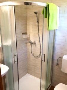 um chuveiro com uma porta de vidro na casa de banho em Süle Apartments & Rooms em Balatonfüred