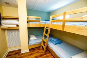 a bunk bed room with three bunk beds and a ladder at Blue Palms Resort in Wildwood