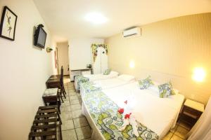 a hotel room with two beds and a staircase at Pousada do Galo in Porto De Galinhas