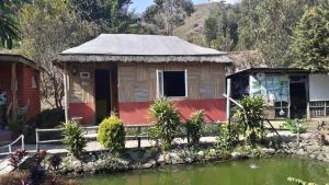 a house with a pond in front of it at Vamoose Sunakhari in Mirik