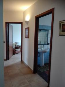 una camera con bagno dotato di lavandino e specchio di Casa Vacanza d'arte Salentina a Specchia