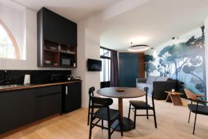 a kitchen and living room with a table and chairs at Les Apparts de Marin in Laval