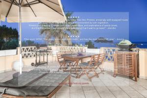 a table and chairs and an umbrella on a patio at Exotic Master-House in a Unique Location! in Lithakia +28 photos
