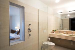 a bathroom with a shower and a sink and a mirror at Hotel Linde in Maria Wörth