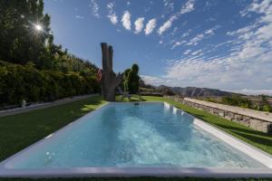 a swimming pool in the middle of a grassy field at Roque nublo rural houses I in Vega de San Mateo