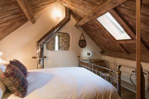 a attic bedroom with a bed and a skylight at Cottage 1 New Yatt Farm in Wilcote