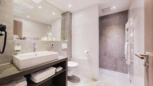 a bathroom with a sink and a toilet at Heuboden Hotel Heu.Loft Freiburg in Umkirch